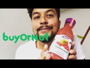 Un jeune homme tient une bouteille de jus de fruit